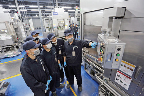 公司工作人员正在B区车间指导新员工学习操作切片设备